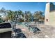 Community outdoor patio with black iron fence, tables, chairs, and a grill at 2101 Sunset Point Rd # 2706, Clearwater, FL 33765