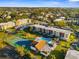 Aerial view showcasing the community pool, tennis court, and condo buildings at 2440 Winding Creek Blvd # 305, Clearwater, FL 33761