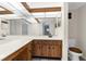Well-lit bathroom featuring double sinks, spacious countertop, and wooden cabinetry at 2440 Winding Creek Blvd # 305, Clearwater, FL 33761