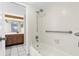 Clean bathroom featuring shower-tub combo with grab bar, bright tiles, and wooden vanity at 2440 Winding Creek Blvd # 305, Clearwater, FL 33761