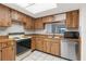 Kitchen with wood cabinets, stainless steel dishwasher, and a view from the sink at 2440 Winding Creek Blvd # 305, Clearwater, FL 33761
