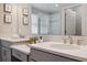 Bright bathroom featuring a large mirror, double vanity with quartz countertop and tiled floors at 29917 Southwell Ln, Wesley Chapel, FL 33543