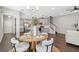 Open-concept dining area with a wood table and seating, flowing into the kitchen with gray cabinets and stainless appliances at 29917 Southwell Ln, Wesley Chapel, FL 33543