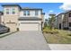 Inviting townhome showcases a paved driveway, lush lawn, and attached two-car garage at 29917 Southwell Ln, Wesley Chapel, FL 33543