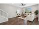 Open-concept living room with dark wood floors, comfortable seating, and a staircase leading to the upper level at 29917 Southwell Ln, Wesley Chapel, FL 33543