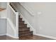 Staircase with wood treads and white risers, connecting the home's levels, and a view of the kitchen at 29917 Southwell Ln, Wesley Chapel, FL 33543