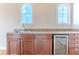 Wet bar with dark wood cabinets, stone countertops, wine fridge, and arched windows at 3073 Gulf Winds Cir, Hernando Beach, FL 34607