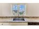 A granite countertop with a stainless steel kitchen sink overlooking a beautiful home at 3073 Gulf Winds Cir, Hernando Beach, FL 34607
