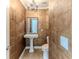 Chic powder room featuring unique tile work, pedestal sink, and elegant chandelier at 3073 Gulf Winds Cir, Hernando Beach, FL 34607