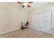 Carpeted bedroom with a ceiling fan and an exercise bike and double closet at 33501 Prospect Rd, Dade City, FL 33525