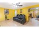 Inviting living room with a comfortable black leather sofa and a ceiling fan at 3542 Connon Dr, New Port Richey, FL 34652