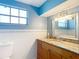 Bright bathroom with a granite countertop vanity, white tile, and large mirror at 3640 Richboro Dr, Holiday, FL 34691