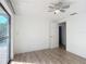 Bright, airy bedroom with neutral walls, ceiling fan, and sliding glass door access to the outside at 3640 Richboro Dr, Holiday, FL 34691