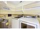 Bright laundry room features modern washer and dryer units, water heater, and lots of shelving for easy organization at 3640 Richboro Dr, Holiday, FL 34691