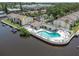 Aerial view of the waterfront condo community with swimming pool, boat docks, and landscaping at 432 Moorings Cove Dr. # 432, Tarpon Springs, FL 34689