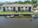 Back exterior view of waterfront condos with boats docked and maintained lawns at 432 Moorings Cove Dr. # 432, Tarpon Springs, FL 34689