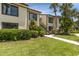 Inviting two-story condo building with lush greenery and a private entrance staircase at 432 Moorings Cove Dr. # 432, Tarpon Springs, FL 34689