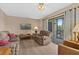 Cozy living room with a sliding glass door that leads to a private balcony at 432 Moorings Cove Dr. # 432, Tarpon Springs, FL 34689