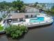 Aerial view of the waterfront condo community pool with lounge chairs and clubhouse at 432 Moorings Cove Dr. # 432, Tarpon Springs, FL 34689