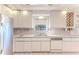 Well-lit kitchen features white cabinetry, tiled backsplash, and a stainless steel refrigerator at 4529 Flounder Dr, Hernando Beach, FL 34607