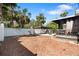 View of the backyard with a covered porch and barbeque area with a wood privacy fence at 6305 S Macdill Ave, Tampa, FL 33611