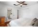 Bright bedroom featuring wood floors, a ceiling fan, closet, and adjoining bathroom with glass shower door at 6305 S Macdill Ave, Tampa, FL 33611