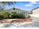 Quaint single-story house featuring a tidy front yard with mulch and lush greenery at 6305 S Macdill Ave, Tampa, FL 33611