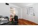 Bright office with wood floors, adjacent living room, desk, and view to backyard at 6305 S Macdill Ave, Tampa, FL 33611