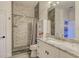 Bathroom featuring a shower with decorative tile surround and a granite countertop vanity with white cabinets at 6734 Dali Ave # 205, Land O Lakes, FL 34637