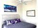 Bedroom with ceiling fan, window and a bed with purple accent pillows and tree art at 6734 Dali Ave # 205, Land O Lakes, FL 34637