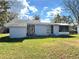 Backyard view of home featuring a well-maintained lawn and a screened in porch at 7017 Mccray Dr, Hudson, FL 34667