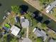 Aerial view of a waterfront property with a dock, boat lift, and outdoor entertaining space at 7235 Maryland Ave, Hudson, FL 34667