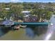 An aerial view of a waterfront home with a dock, boat lift, and an outdoor living space on the water at 7235 Maryland Ave, Hudson, FL 34667