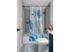 Bright bathroom features a shower over tub, wood-look paneling and coastal-themed decor at 7235 Maryland Ave, Hudson, FL 34667