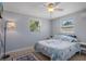 Well-lit guest bedroom featuring a ceiling fan, coastal decor, and tile floors at 7235 Maryland Ave, Hudson, FL 34667