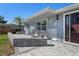 Home's front exterior showcases a stone seating area, lush lawn, and an elegant doorway at 7235 Maryland Ave, Hudson, FL 34667