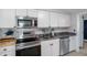 Charming kitchen featuring stainless appliances, granite counters, and white cabinetry at 7235 Maryland Ave, Hudson, FL 34667