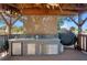 Outdoor kitchen with stainless steel cabinets and granite countertops with a grill and seating area at 7235 Maryland Ave, Hudson, FL 34667