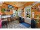 Well-lit sun room with wood walls, vinyl flooring, a TV, mini-fridge and plentiful decor at 7235 Maryland Ave, Hudson, FL 34667