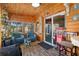 Bright sun room featuring vinyl flooring, wood walls, comfortable seating, and a vintage popcorn machine at 7235 Maryland Ave, Hudson, FL 34667