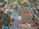 Aerial view of community amenities including pool, tennis courts, parking and lawn game areas at 7514 Rocky Point Dr, Hudson, FL 34667