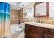 Bathroom features a vanity with marble countertop, tiled walls, and shower-tub combo at 7514 Rocky Point Dr, Hudson, FL 34667