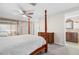 Bedroom featuring a four-poster bed, ceiling fan, and direct access to the bathroom at 7514 Rocky Point Dr, Hudson, FL 34667