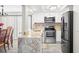 Stylish kitchen with stainless steel appliances, white cabinets, marble countertops, and open dining area at 7514 Rocky Point Dr, Hudson, FL 34667