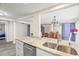 Close-up of kitchen island featuring marble countertop, stainless steel dishwasher, and double sink with views to dining room at 7514 Rocky Point Dr, Hudson, FL 34667