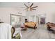Bright living room featuring vaulted ceilings, a large ceiling fan, and sliding glass doors leading to the patio at 7514 Rocky Point Dr, Hudson, FL 34667