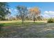 Scenic view of sprawling grounds, featuring mature trees and a serene pond in the background at 7546 St Andrews Blvd, Weeki Wachee, FL 34613