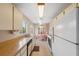 Galley kitchen boasts ample counter space, tile flooring and white appliances and cabinets at 7546 St Andrews Blvd, Weeki Wachee, FL 34613