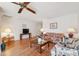 Bright living room with hardwood floors features a ceiling fan and white walls at 7546 St Andrews Blvd, Weeki Wachee, FL 34613