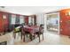 A dining room adjacent to sliding glass doors features tile flooring, a table, and rust-colored walls at 7628 Topay Ln, Port Richey, FL 34668